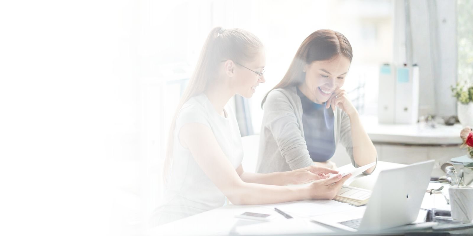 Dos consultoras de Talentium revisando el perfil de un candidato de ventas B2B en una tablet durante una reunión de estrategia.