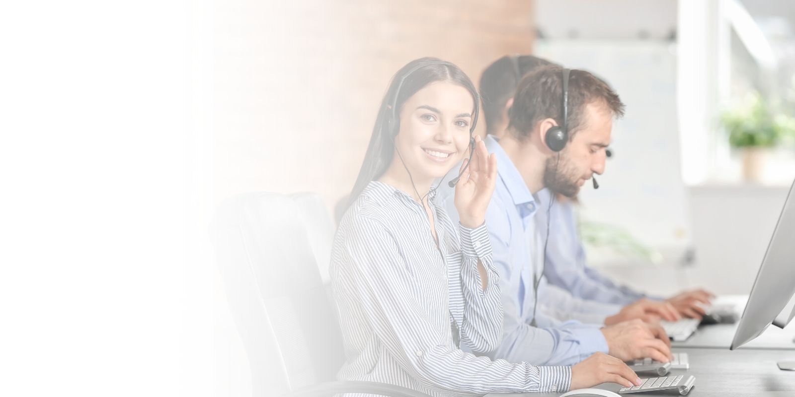 Agente de call center bilingüe sonriendo y usando un headset mientras trabaja en una computadora, representando el talento en el sector de nearshoring en México.